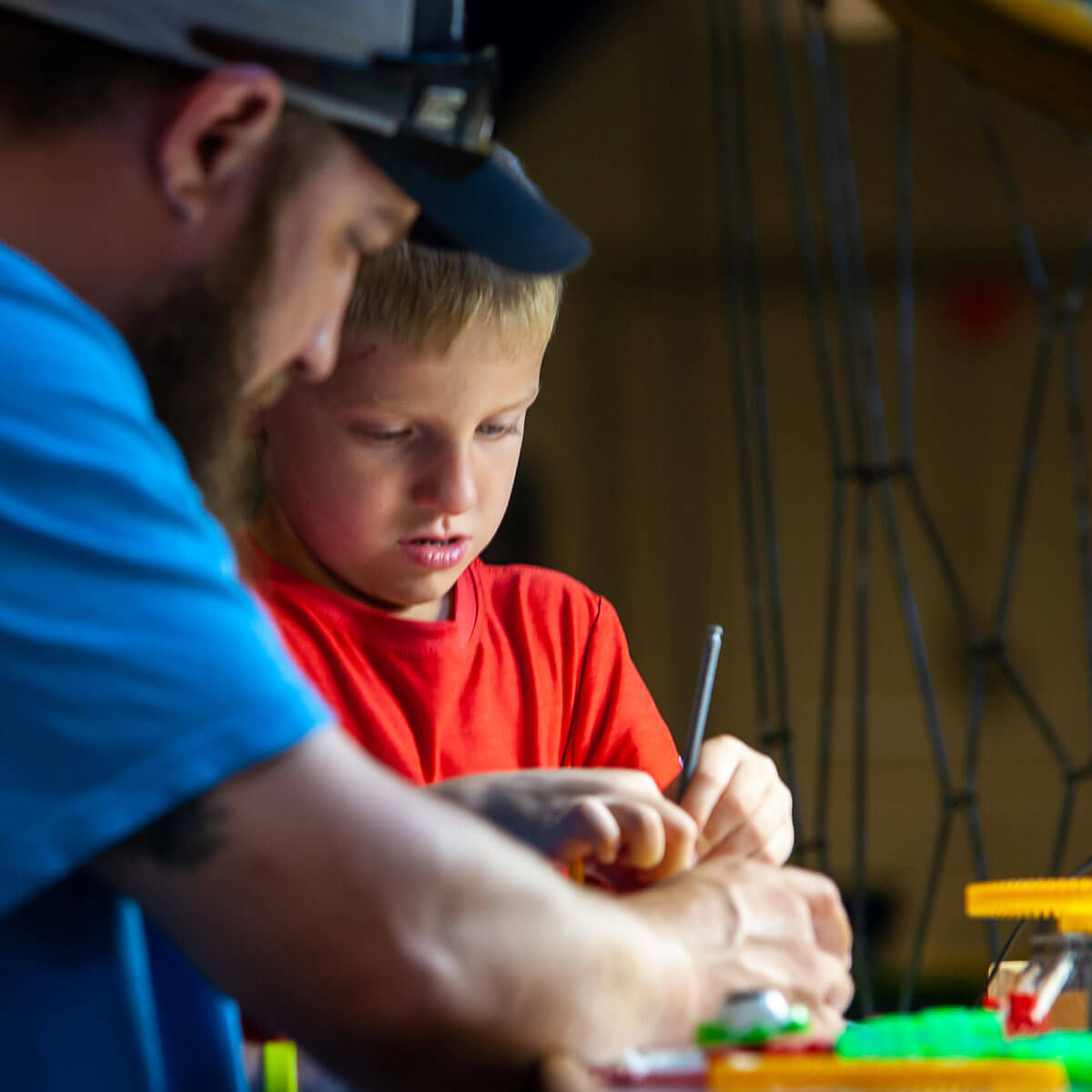 A child plays with KNex at Wonderlab while an ad