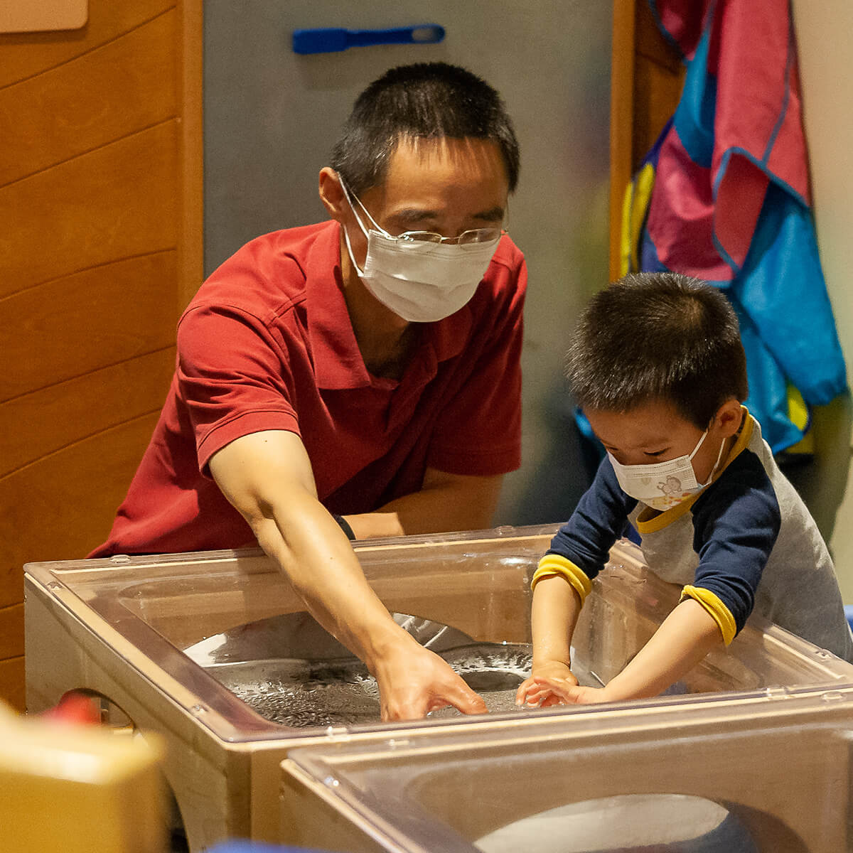 A toddler and their caregiver interact with an activity at Science Sprouts Place
