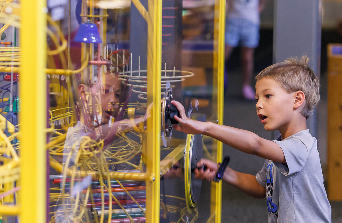A boy looks on in amazement as he interacts with the Kinetic Contraption at Wonderlab, Bloomington