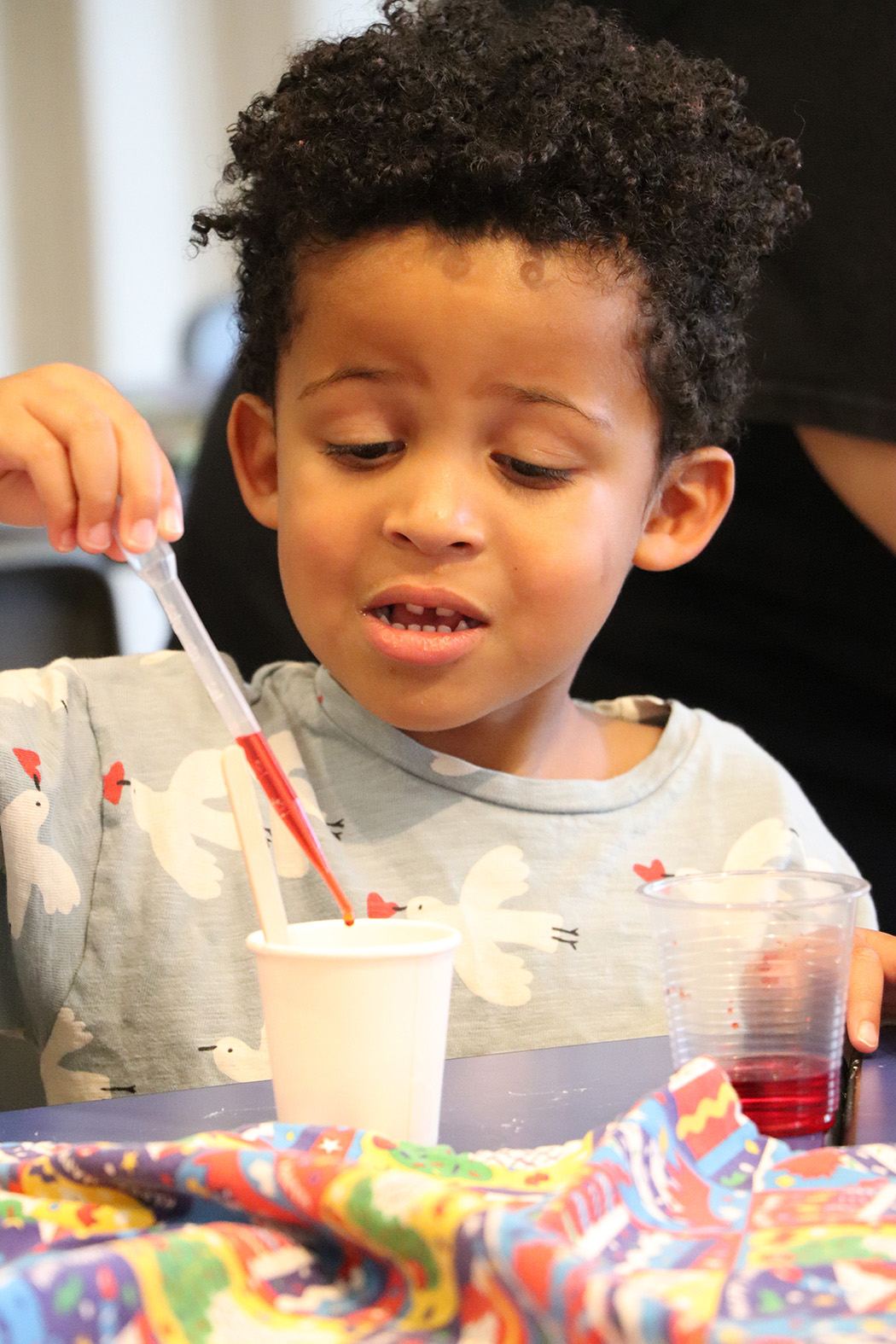 A young boy performs a chemistry experiment during a WonderLab birthday party.